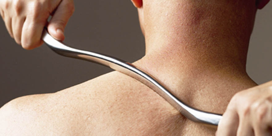 IASTM/Graston tool gliding along forearm muscle